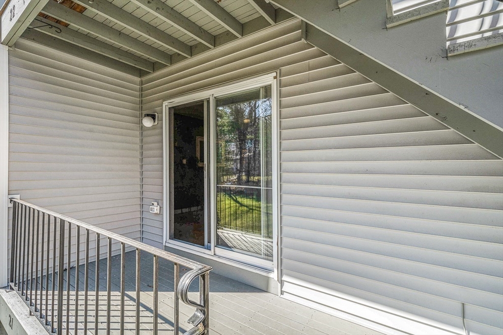 124 Tennis Plaza Road, Unit 21 Dracut, MA 01826 - Photo 24 of 27 a view of a balcony with stairs and wooden floor