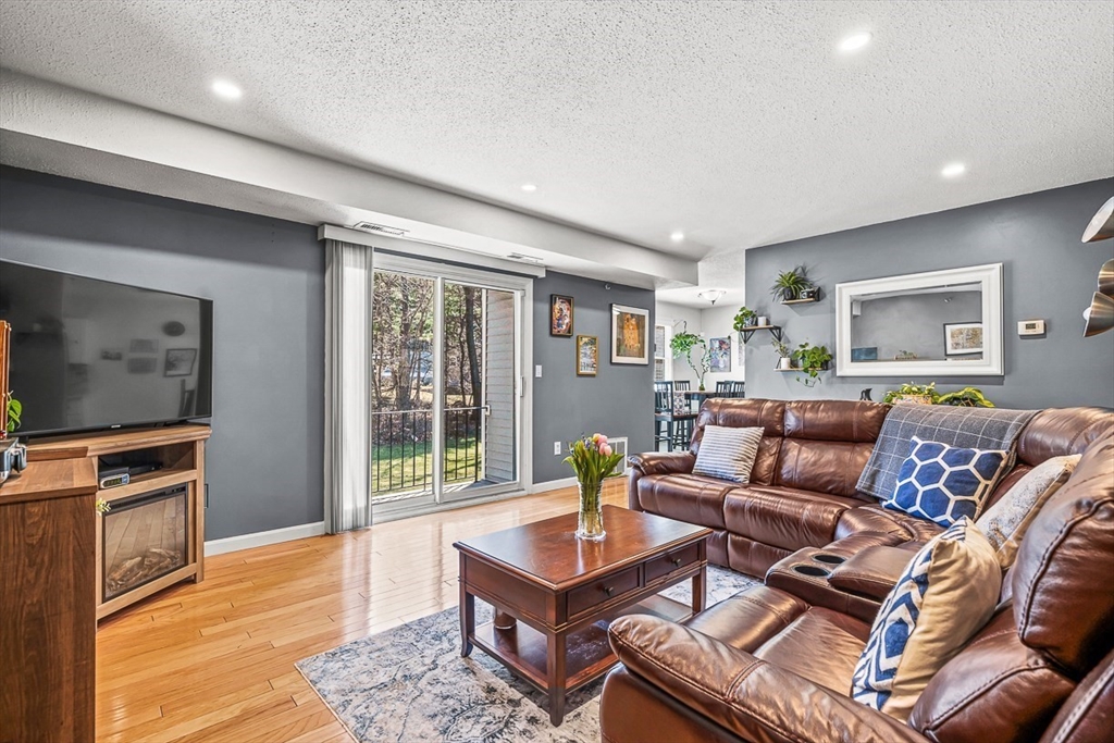 124 Tennis Plaza Road, Unit 21 Dracut, MA 01826 - Photo 7 of 27 a living room with furniture and a flat screen tv