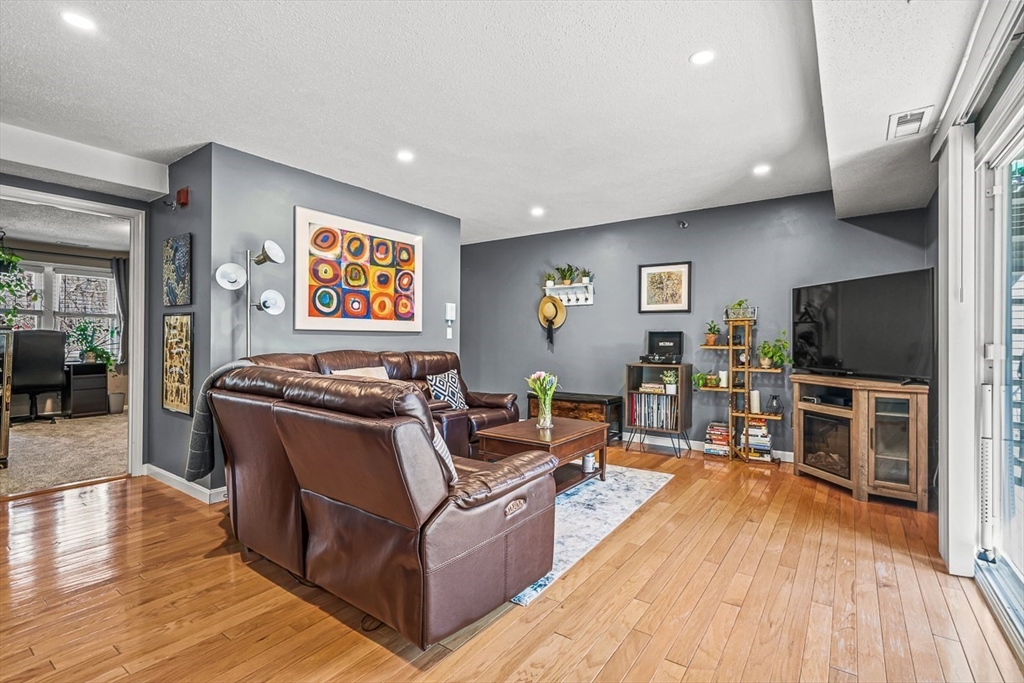 124 Tennis Plaza Road, Unit 21 Dracut, MA 01826 - Photo 8 of 27 a living room with furniture and a flat screen tv