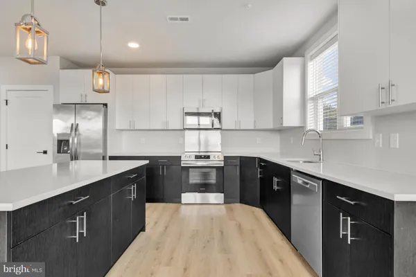 a kitchen with stainless steel appliances granite countertop a sink a stove and refrigerator