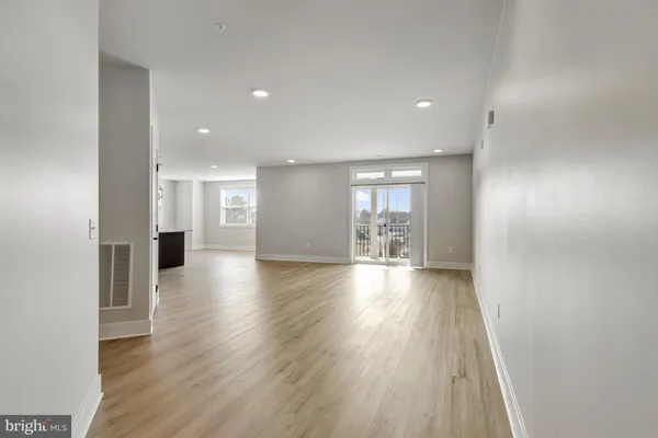 a view of a big room with wooden floor and windows