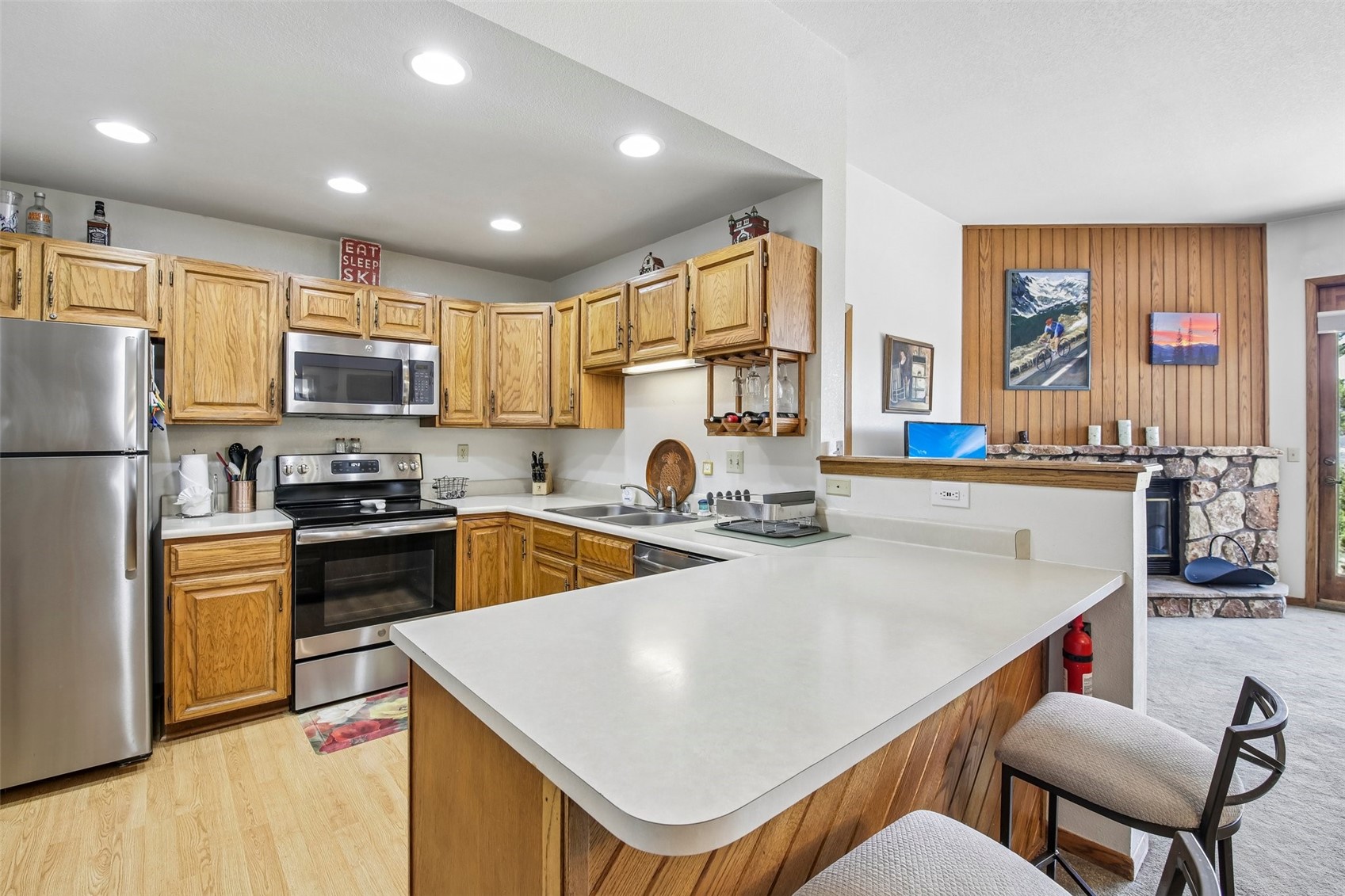 89310 Ryan Gulch Road, Unit 103 Silverthorne, CO 80498 - Photo 8 of 48 a kitchen with stainless steel appliances granite countertop a sink a stove a refrigerator a microwave oven with a dining table and chairs