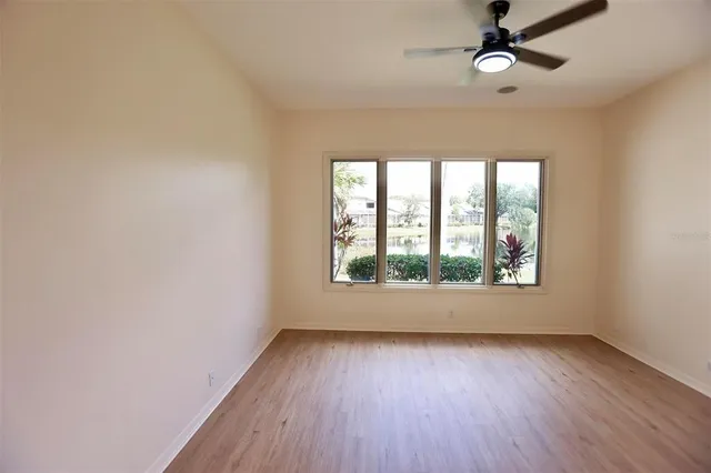 an empty room with wooden floor and windows