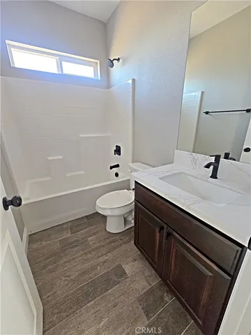 a bathroom with a sink a toilet a mirror and shower