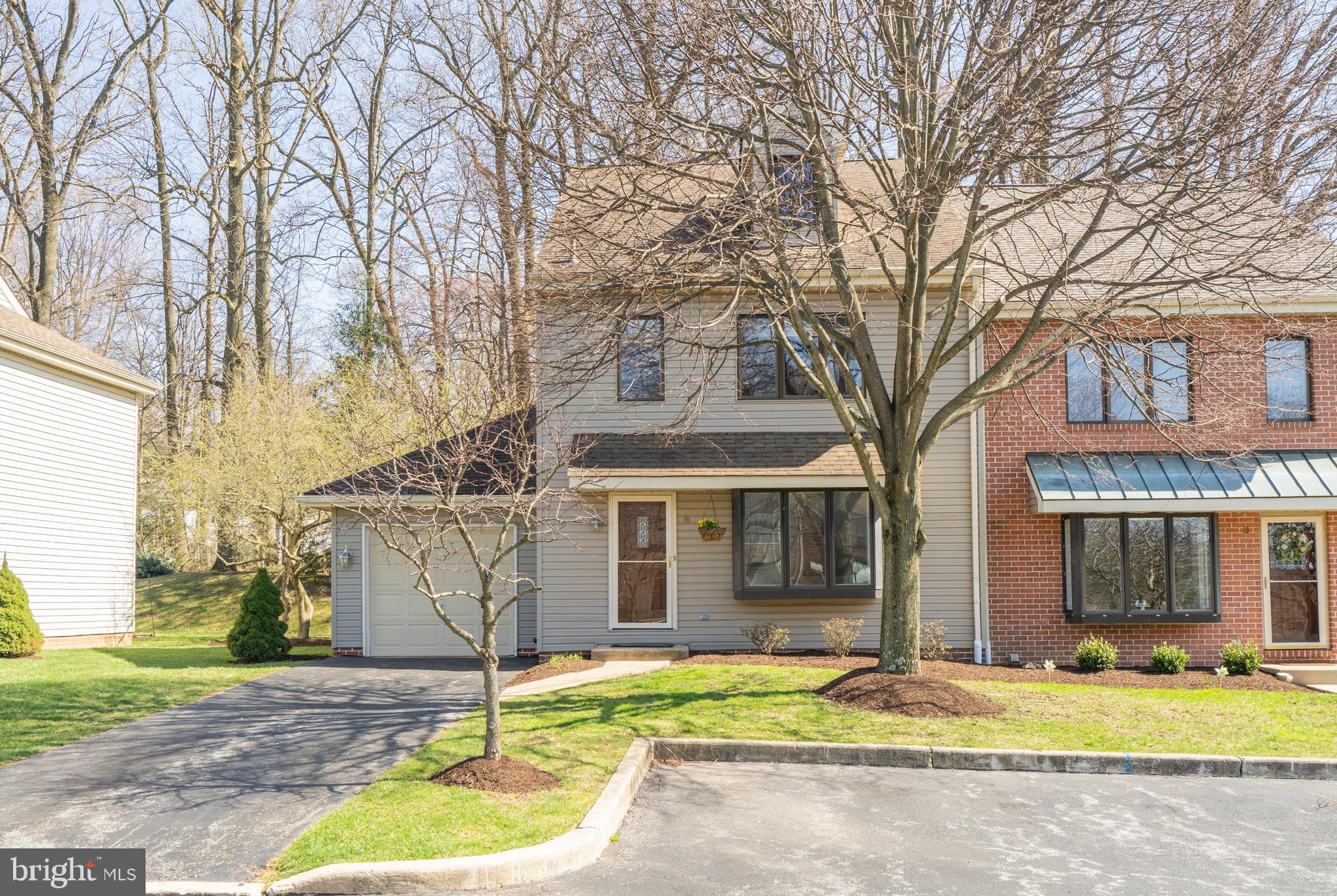 Front of home with private drive and garage
