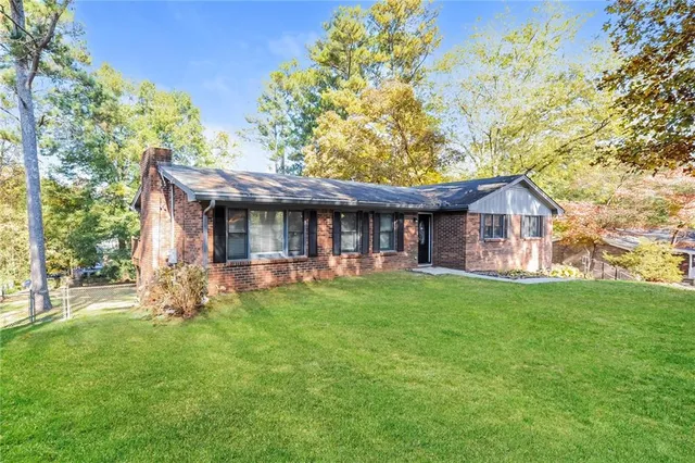 a view of a house with a yard and sitting area