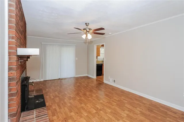 a view of a room with a ceiling fan and a hardwood floor