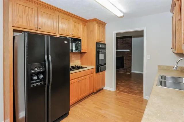 a kitchen with stainless steel appliances granite countertop a refrigerator and a sink
