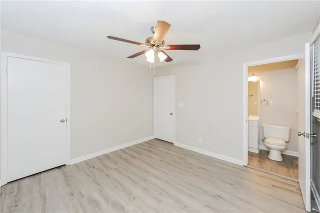wooden floor in an empty room with a bathroom
