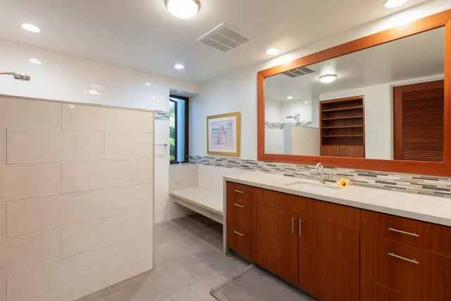 a bathroom with a granite countertop sink and a large mirror