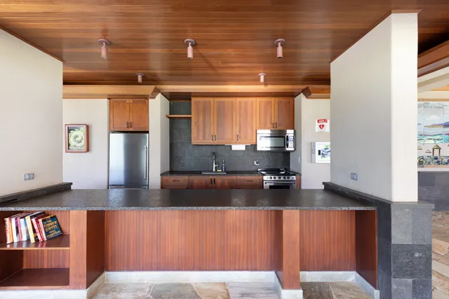 a kitchen with stainless steel appliances granite countertop a refrigerator and a stove