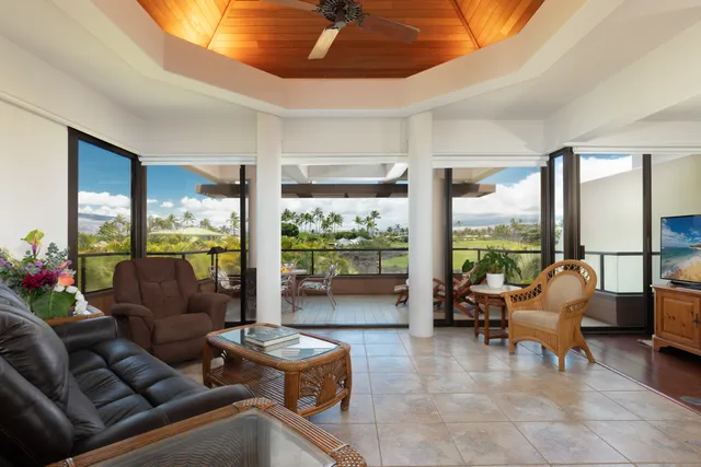 a living room with furniture and floor to ceiling windows