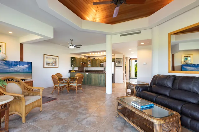 a living room with furniture a large window and stainless steel appliances