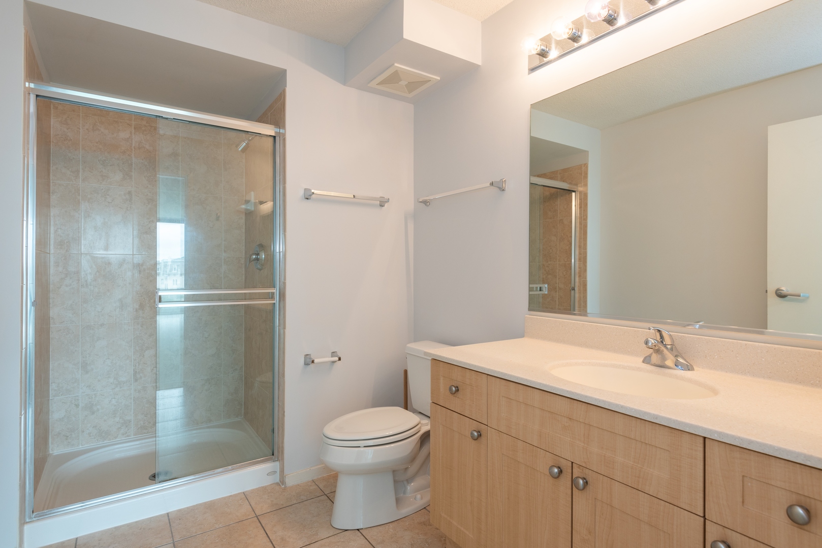 800 Elgin Road, Unit 711 Evanston, IL 60201 - Photo 13 of 18 a bathroom with a shower sink vanity mirror and toilet