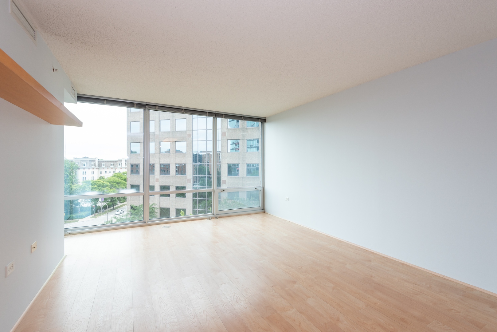 800 Elgin Road, Unit 711 Evanston, IL 60201 - Photo 5 of 18 a view of an empty room with wooden floor and a window