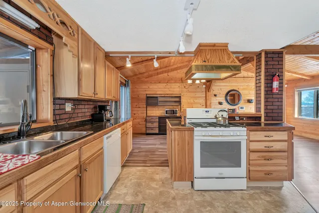 a large kitchen with stainless steel appliances granite countertop a stove and cabinets