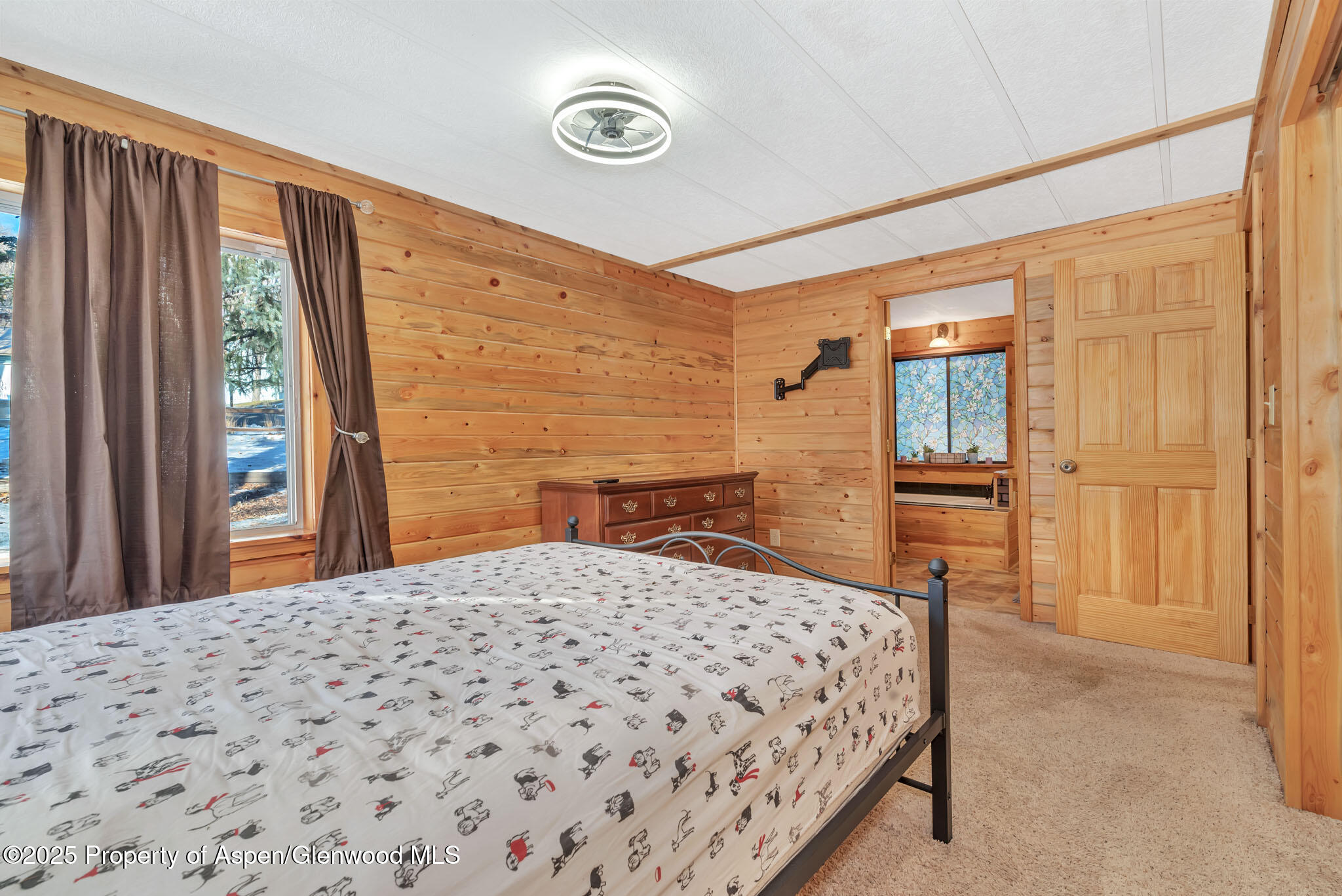 759 Ashley Road Craig, CO 81625 - Photo 21 of 44 a bedroom with a large bed and a chandelier