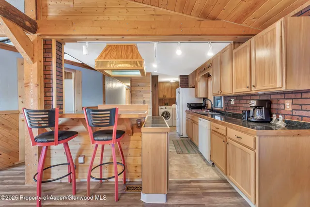 a kitchen with stainless steel appliances kitchen island granite countertop a refrigerator and microwave