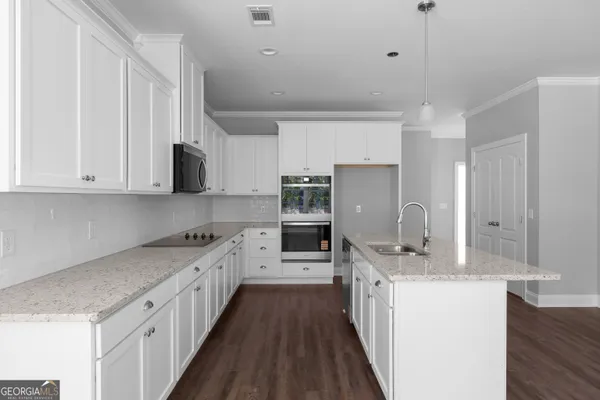 a kitchen with stainless steel appliances a sink stove and cabinets
