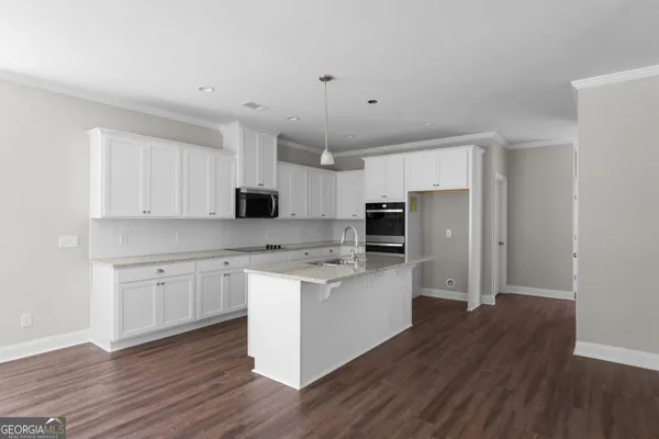 a kitchen with stainless steel appliances a sink cabinets and wooden floor
