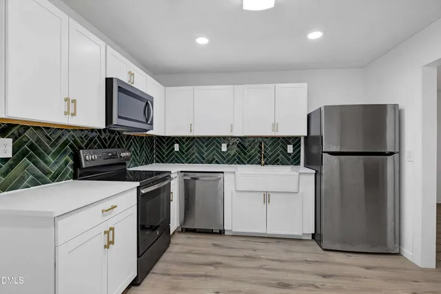 a kitchen with white cabinets and refrigerator