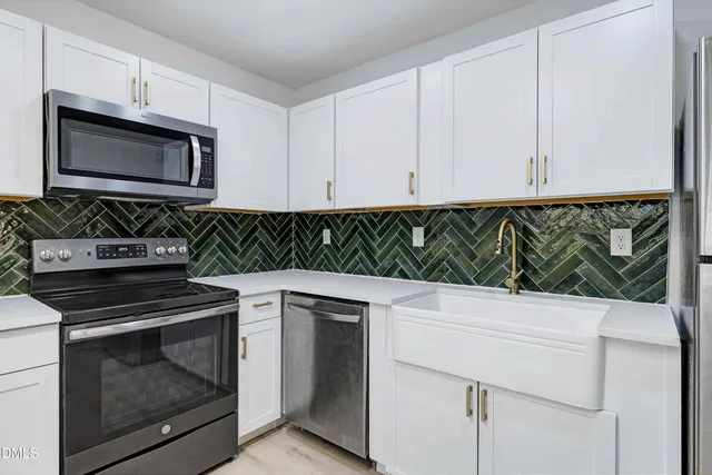 a kitchen with white cabinets and a stove top oven