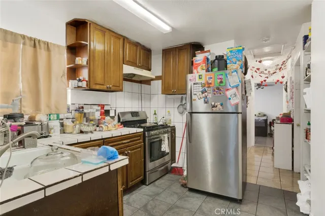a kitchen with stainless steel appliances granite countertop a refrigerator and a sink
