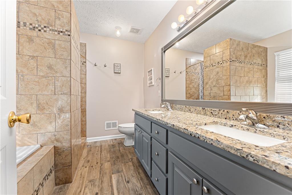 190 Timber Ridge Drive McDonough, GA 30252 - Photo 14 of 29 a bathroom with a granite countertop double vanity sink a mirror and a shower