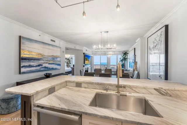 a view with a sink a counter top space and living room view