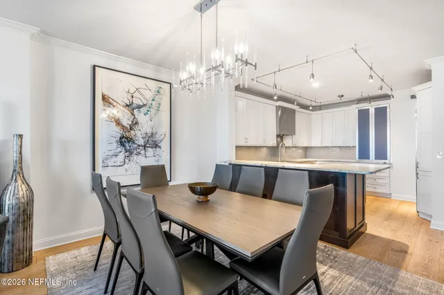 a view of a dining room with furniture a chandelier and wooden floor