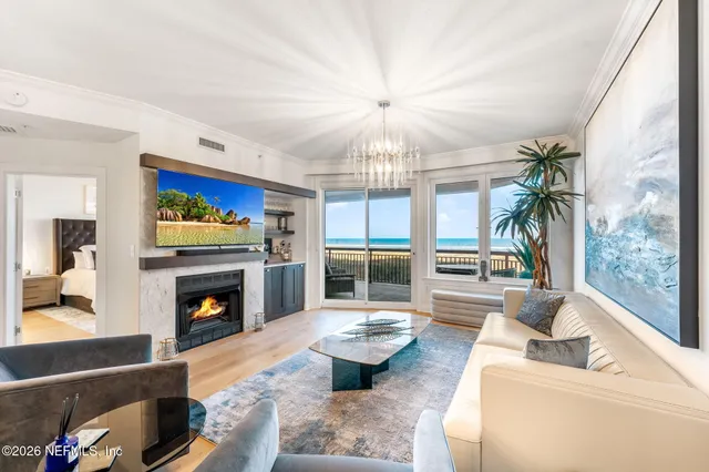 a living room with furniture fireplace and a large window