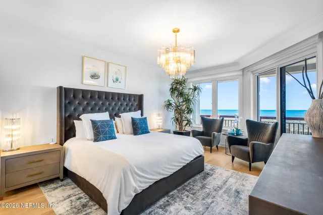 a spacious bedroom with bed and a chandelier