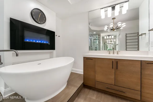 a bathroom with a sink a large mirror and a bathtub