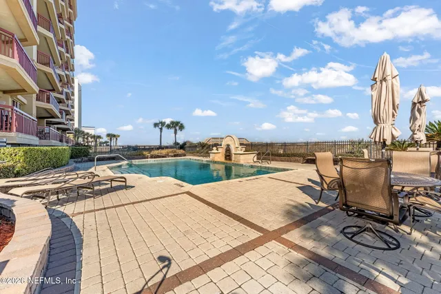 a view of a balcony with wooden floor and palm trees