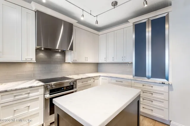 a kitchen with a stove a sink and cabinets
