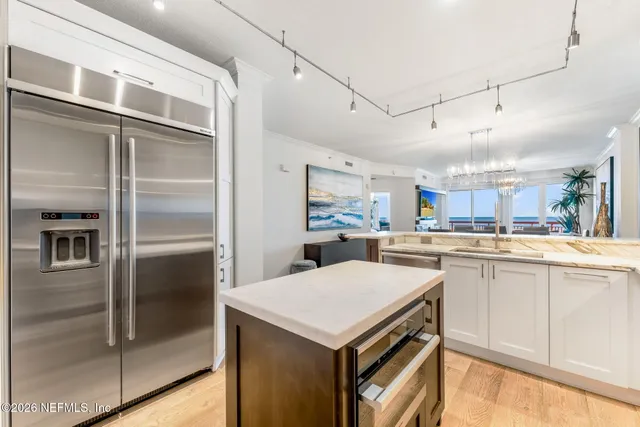 a kitchen with a refrigerator and white cabinets