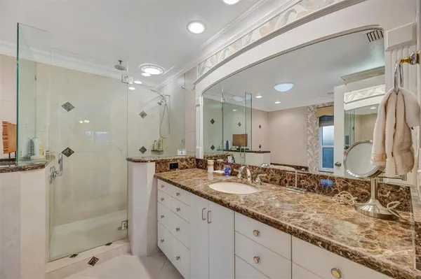 a bathroom with a granite countertop sink mirror and shower