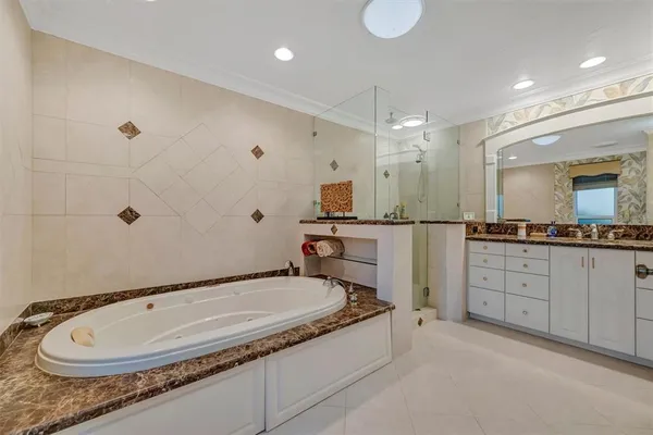 a bathroom with a granite countertop sink mirror and bathtub