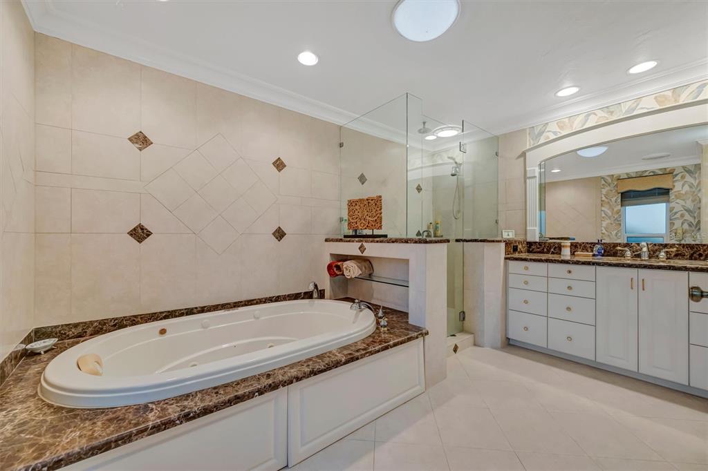 4859 Greencroft Road Sarasota, FL 34235 - Photo 14 of 39 a bathroom with a granite countertop sink mirror and bathtub