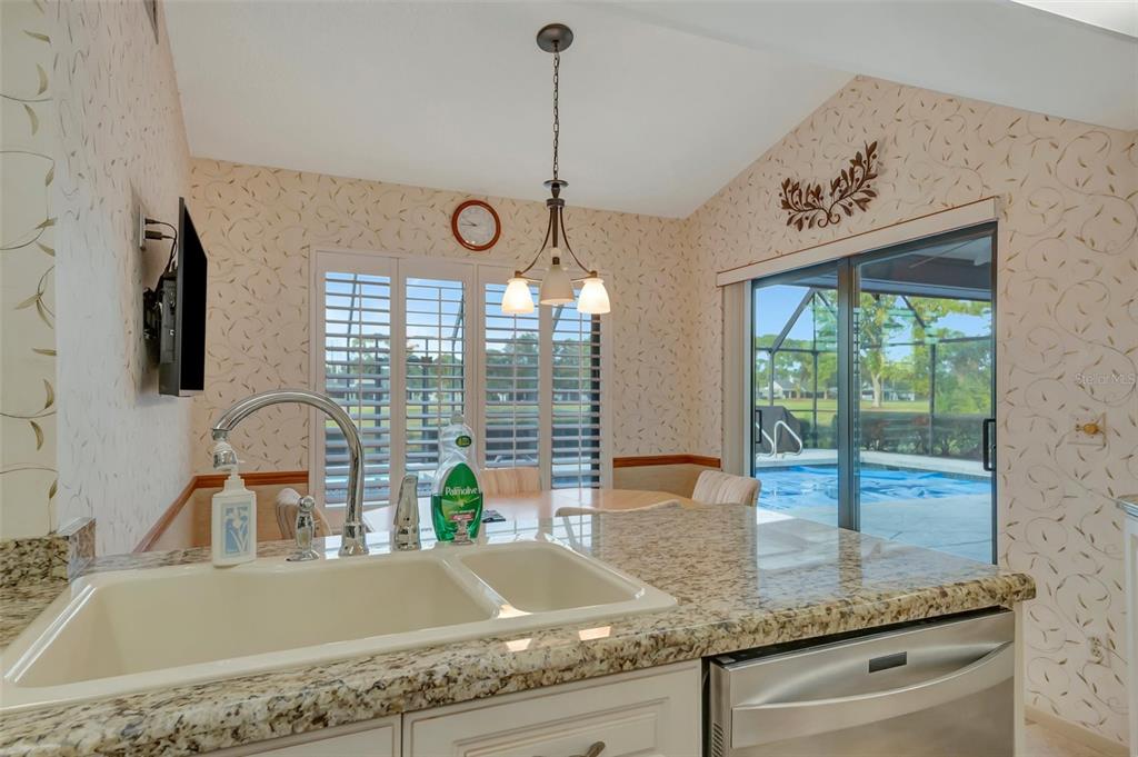 4859 Greencroft Road Sarasota, FL 34235 - Photo 18 of 39 a kitchen with a granite countertop sink and a large window