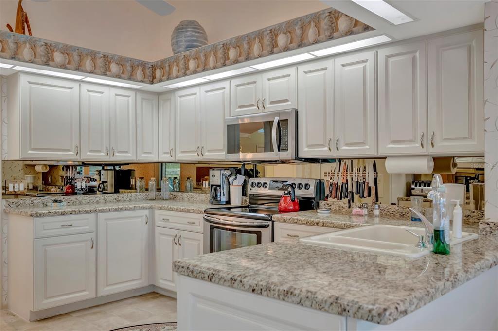 4859 Greencroft Road Sarasota, FL 34235 - Photo 20 of 39 a kitchen with stainless steel appliances granite countertop a sink and cabinets