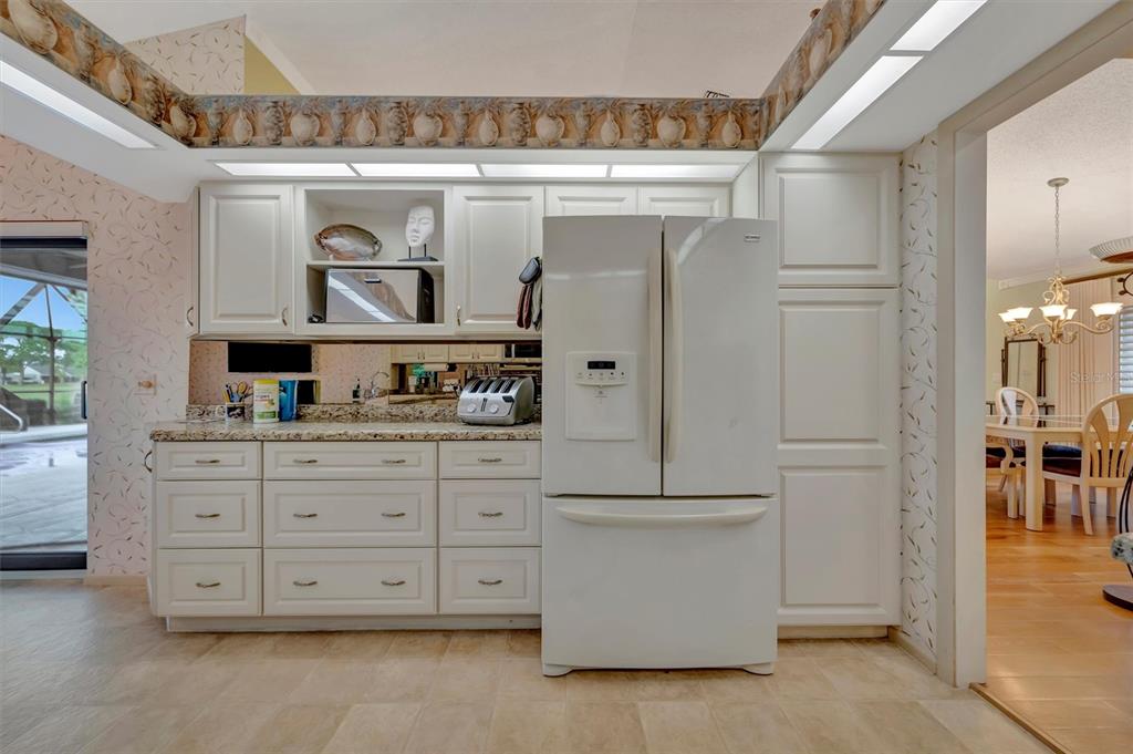 4859 Greencroft Road Sarasota, FL 34235 - Photo 22 of 39 a kitchen with stainless steel appliances granite countertop a refrigerator and a cabinets