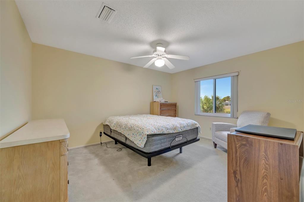 4859 Greencroft Road Sarasota, FL 34235 - Photo 23 of 39 a bedroom with a bed chandelier and a window
