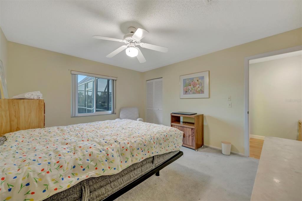 4859 Greencroft Road Sarasota, FL 34235 - Photo 24 of 39 a bedroom with a large bed and a chandelier