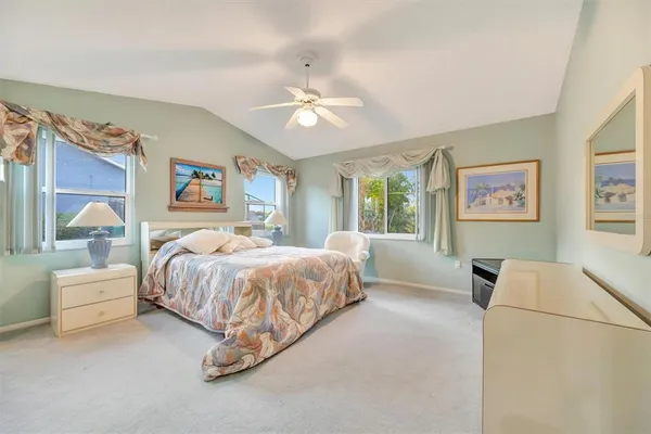 a spacious bedroom with a bed painting on wall and a large window