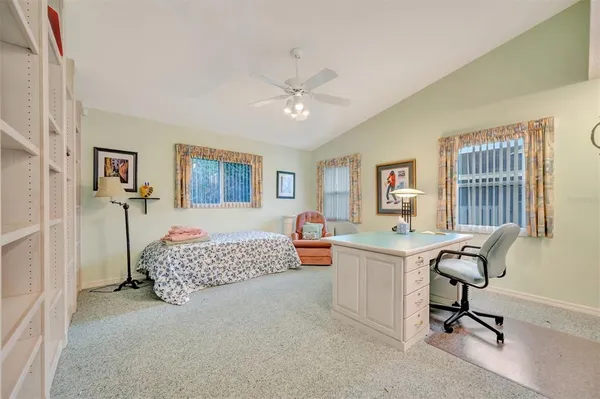 a view of a bedroom with workspace and a window
