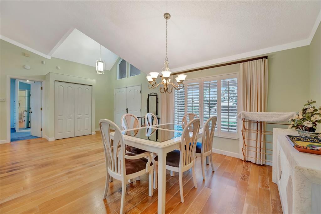 4859 Greencroft Road Sarasota, FL 34235 - Photo 6 of 39 a dining room with furniture a chandelier and wooden floor