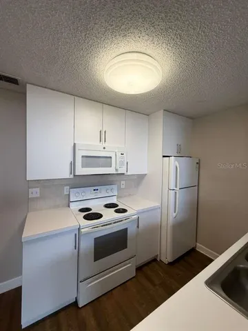 a kitchen with a refrigerator stove and white cabinets