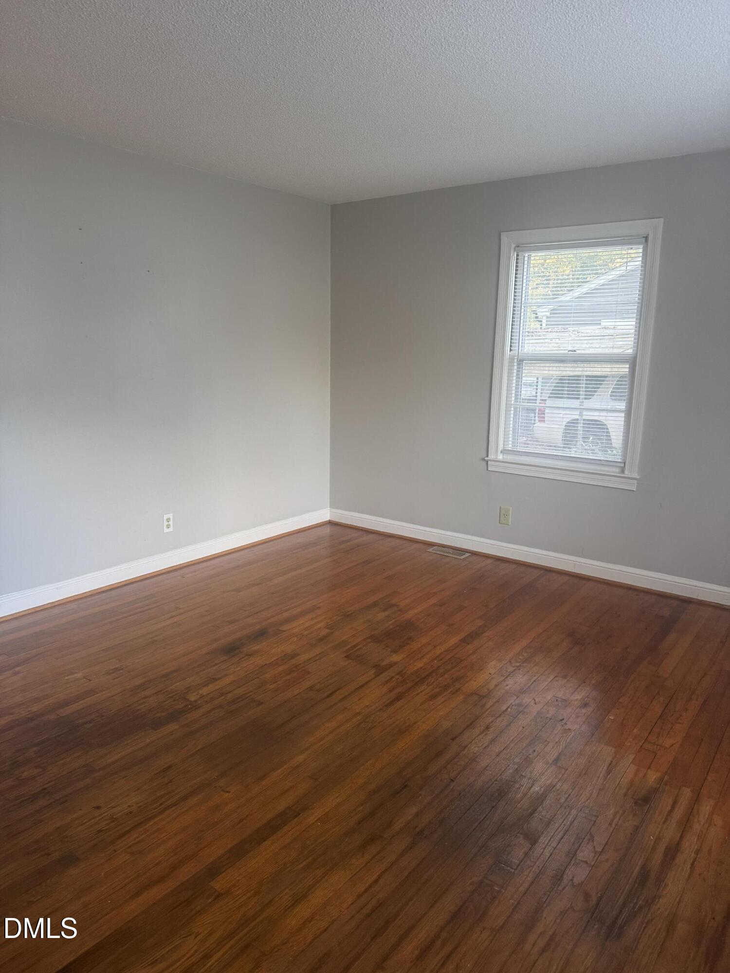 101 Joy Street Dunn, NC 28334 - Photo 5 of 14 a view of an empty room with wooden floor and a window