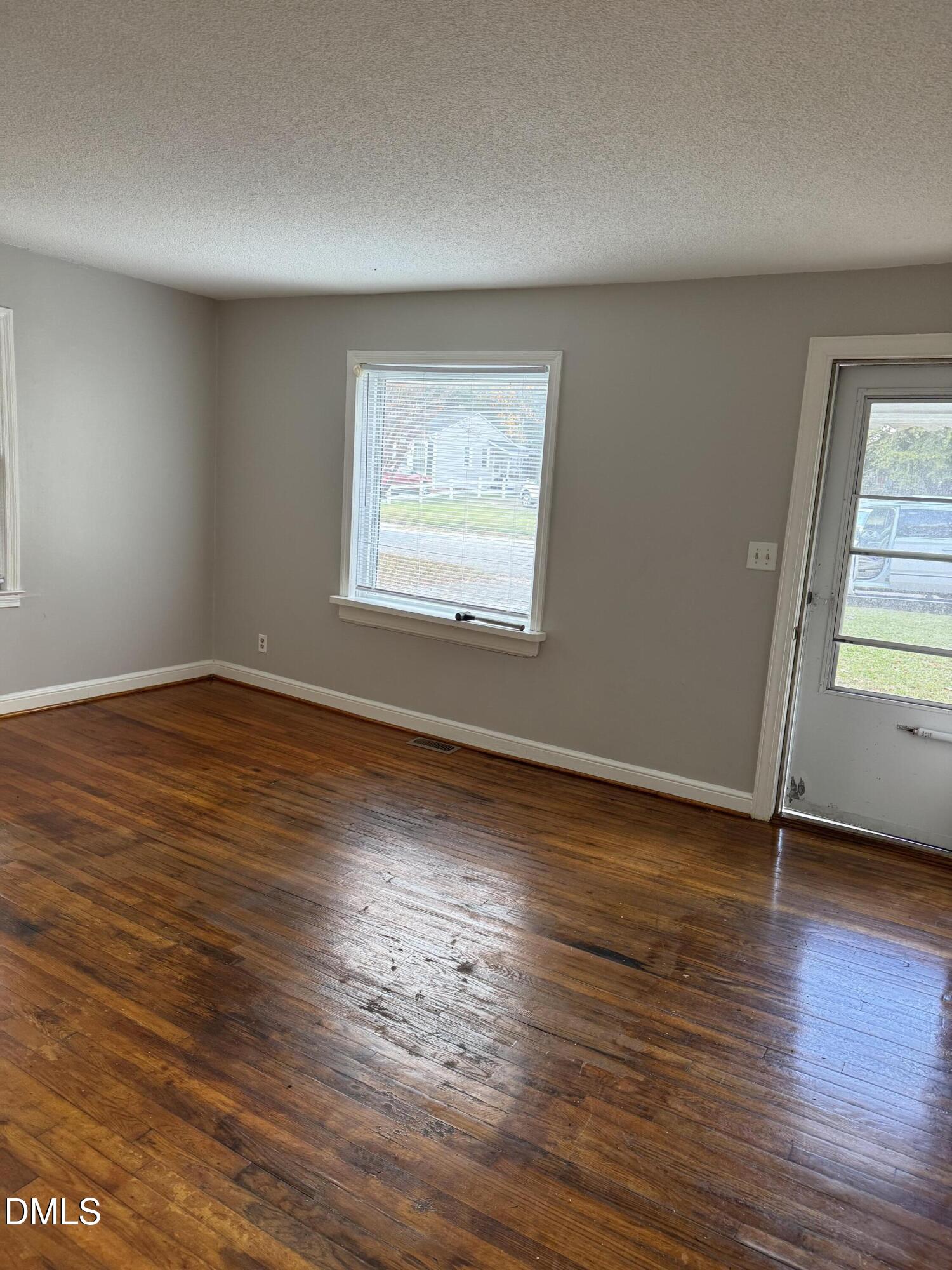 101 Joy Street Dunn, NC 28334 - Photo 6 of 14 an empty room with wooden floor and windows
